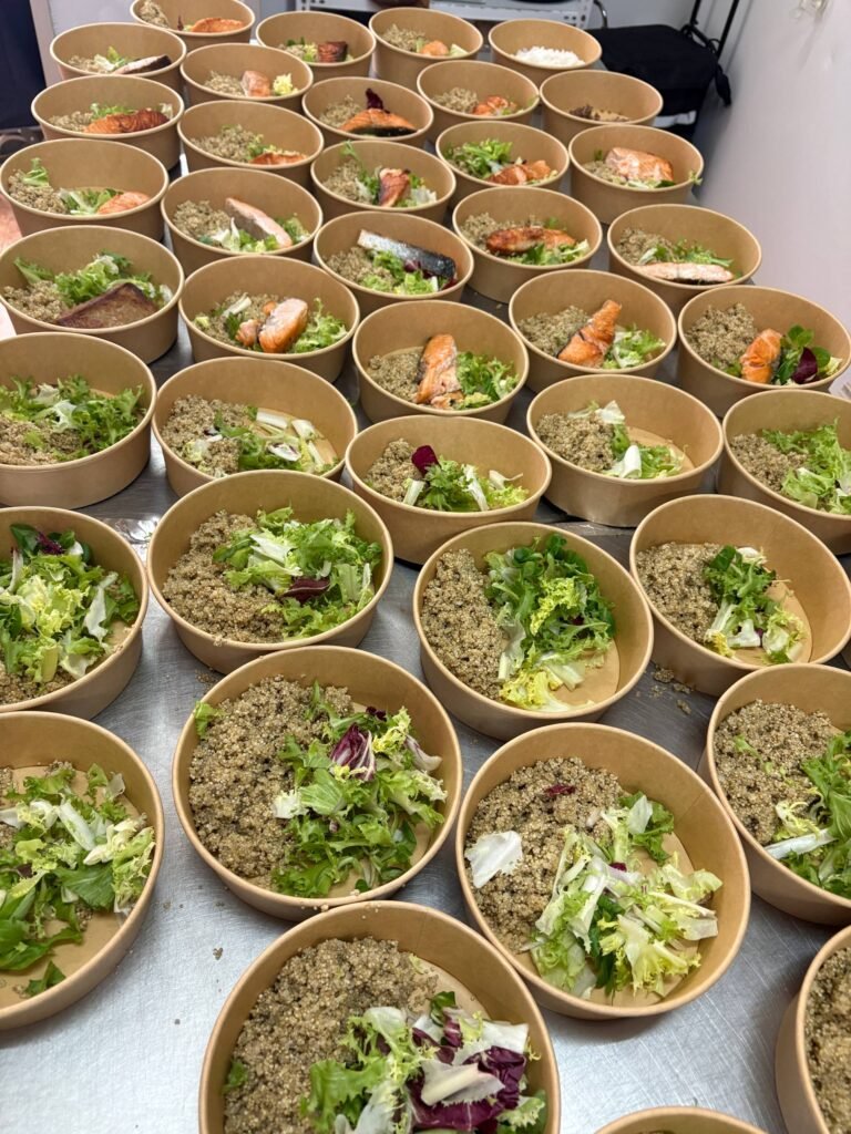 Montaje por la mañana de bowls de salmón y quinoa en la cocina Llévatelo en Valencia