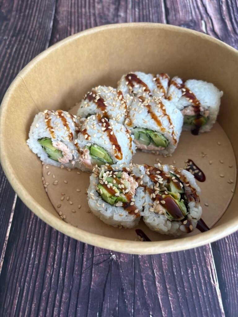 Rollos de sushi con aguacate y pescado en envase kraft